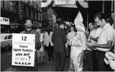 NAACP member protesting segregated hotels near a Klansman, 1962