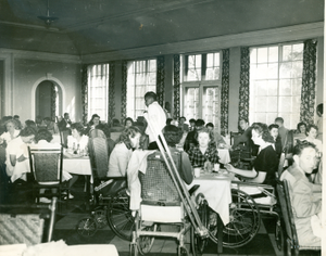 Photograph of a group of Georgia Warm Springs Foundation patients and staff eating a meal in the Georgia Hall dining room at the Georgia Warm Springs Foundation, Warm Springs, Meriwether County, Georgia, 1937-1947?