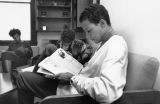 Educational Opportunity Program students read magazines in a lounge, circa 1990