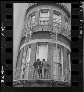 View of two people outside on ironwork balcony of Boston University administration building