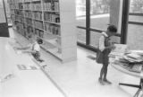 Little boy and girl looking at magazines and books on a table at the Montgomery Public Library.