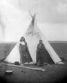 Rain-in-the-Face and wife outside tepee