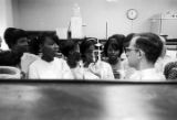 Man explaining scientific equipment to a group of students from Lee County, Alabama, during a field trip to Auburn University.