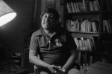 Gaines seated talking in front of bookshelves (EGP-9 #292)