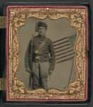 [Unidentified soldier in Union uniform and fez with bayoneted musket in front of painted backdrop showing American flag]