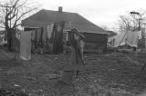 Mrs. Rosa Lee Turner hanging laundry on a clothesline in the dirt yard behind her house in Montgomery, Alabama.