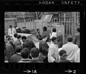 People gathered around rear gates of Boston University building