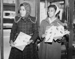 Two African-American women holding up issues of the magazine Score, June 26, 1960