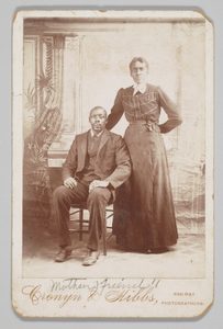 Thumbnail for Photograph of a man sitting down with a woman standing next to him