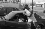 Two men posing with a car at a Blue Castle grand opening, Los Angeles, 1985