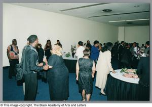 A crowd of Tribute attendees spread out in the gallery space