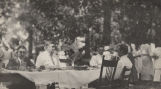 J. L. Sibley and three other men, eating at a table in the woods in rural Alabama.