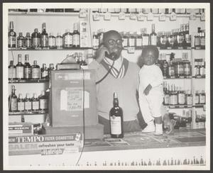 Man Behind Counter with a Toddler