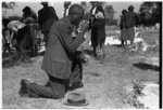 Negro crossing himself and praying over grave of relative in cemetery, All Saints' Day, New Roads, Louisiana