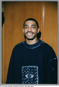 Medium shot of a man smiling at the camera, wearing a sweater, smiling at the camera