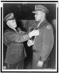 [Brig. Gen. Joseph E. Bastion pins the Distinguished Service Cross on Capt. Charles L. Thomas, commander of a tank destroyer company in France]