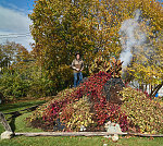 Stewart Melrose, standing tall here, is an interior designer and historical preservationist in Fenton, Michigan. He picked up a love of ornamental gardening from his father and mother, Howard and Sonya Melrose. Together, they created and regularly expand a remarkable garden beside the parent's home. It includes tropical flowers collected worldwide, stone piles called "cairns," and larger rock sculptures, one of which (shown) occasionally erupts with smoke like a volcano. The Melroses consider their creation a community garden, open to all