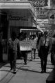 Protestors carrying signs while marching past Murphy's Prescription Drugs in downtown Prattville, Alabama, during a civil rights demonstration.