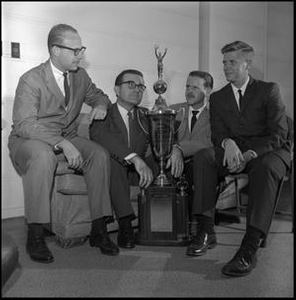 Leon Breeden and others sitting with jazz trophy