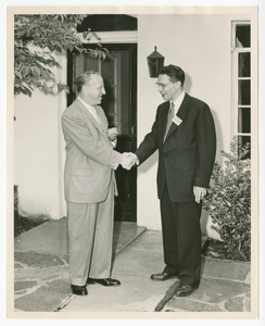 Photograph of Gilbert E. DeLorme. Sr., shaking hands with an unidentified man