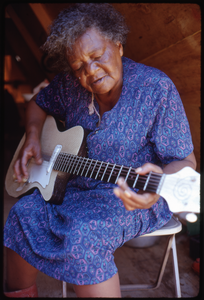 Older woman in tent playing an electric guitar, Resurrection City encampment