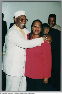 Photograph of Albert Lipscomb and a woman in red posing for a photo