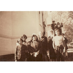 A group of people gather near the stairs of a building