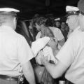 Police officers arresting Catherine Burks Brooks after the Freedom Riders arrived at the Greyhound station in Birmingham, Alabama.