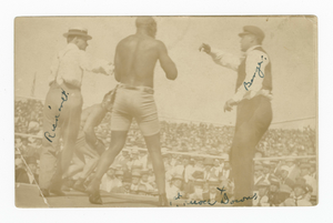 Photographic postcard of James J. Jeffries staggering away from Jack Johnson