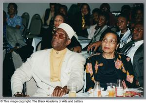 Photograph of Albert Lipscomb sitting at a dining table alongside a woman