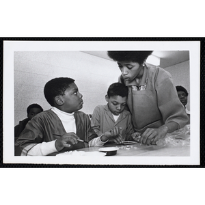 An art instructor talks to one of the students during an arts and crafts class at the Roxbury Boys' Club