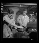 NYA (National Youth Administration) work center, Brooklyn, New York. Two men, white and Negro, who are receiving training in machine shop practice, shown setting up shaper work to cut forty-five degree angles at base for surface gauge
