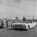 President John F. Kennedy riding in a convertible past a crowd at the Redstone Army Airfield in Huntsville, Alabama.