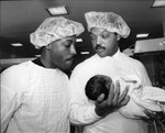 Jesse Jackson holding a newborn baby with Arsenio Hall, Los Angeles