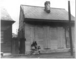 [Three African American girls standing on doorstep of a house]