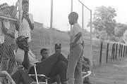 Man speaking to a young boy during a boys' baseball game, probably in Montgomery, Alabama.