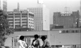 Three students study in an empty lot, 1982