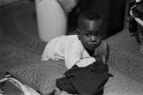 Michael Dabney leaning on a bed in his home in Montgomery, Alabama.