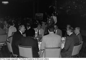 Photograph of a group of men sitting at a dining table