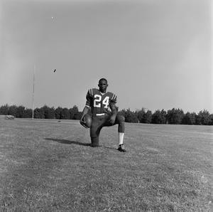 Football player kneeling with a ball, 21