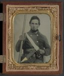 [Unidentified soldier in Confederate uniform with musket, D guard Bowie knife, and engraved knife sheath]