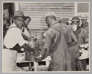 WASECA – BARBADOS ISLAND STORY: FILLING CUPS AT COFFEE URN AT END OF CHOW LINE