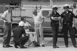 White men and police officers observing a United Klans of America march and rally in Mobile, Alabama.