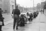 Fred Shuttlesworth and other civil rights demonstrators kneeling before a police officer during a protest march in downtown Birmingham, Alabama.