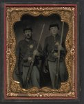 [Two unidentified soldiers in Union shell jackets and forage caps with cartridge pouches, cap boxes, and bayonet scabbards; one soldier in Company C 85th regiment cap; other soldier has holstered pepperbox revolver]