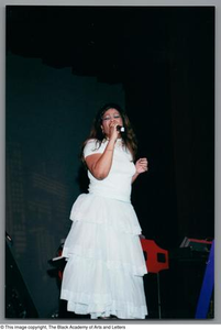 Miki Howard singing onstage in all white garb