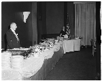 Man and woman standing behind buffet table