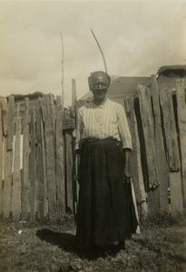 Gullah woman standing in front of a fence