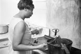 Woman frying chicken in the kitchen at Tom's Place at 648 South Holt Street in Montgomery, Alabama.