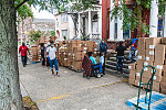 Kendall distributing donated boxes of bread to passersby.  Saint James Social Services Corporation, 604 Martin Luther King Blvd., Newark